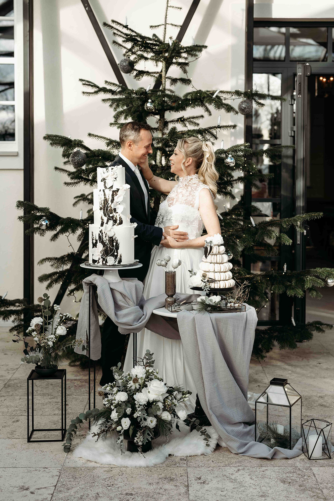 Brautpaar, Mann im schwarzen Hochzeitsanzug, Frau in weißem Hochzeitskleid vor der Hochzeitstorte im Schloss Gurhof