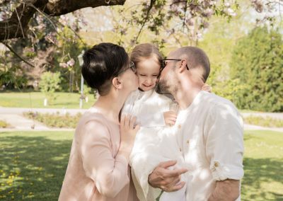 Vater und Mutter küssen Tochter