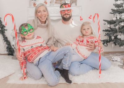 Familie mit Weihnachtsbrillen und Dekoration