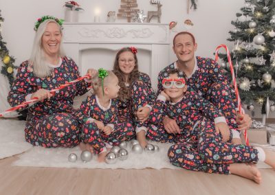 Familie in Weihnachtspyjama und Weihnachtsschmuck