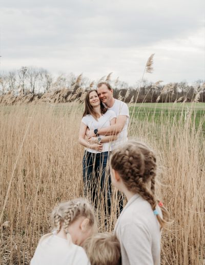 Vater, Mutter und drei Kinder in einem Grasfeld