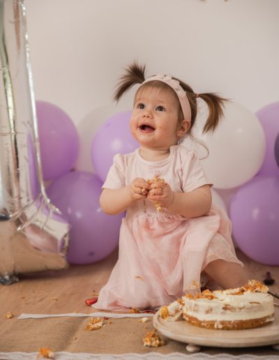 Kleinkind mit Torte und rosa Kleid