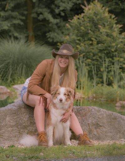 Blonde Frau mit Westernhut und ihrem Hund